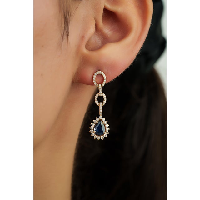 These elegant drop earrings feature 1.61 carats of pear-shaped blue sapphires, set in 14K yellow gold. The sapphire...