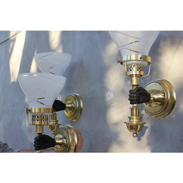 Series of 3 electrified wall lights from the 50s - 60s in gilded and patinated bronze. White glass lampshade. Very...
