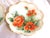 This is a lot of three matching, but not matching plates with orange flowers on a green background. The plates have a gold...