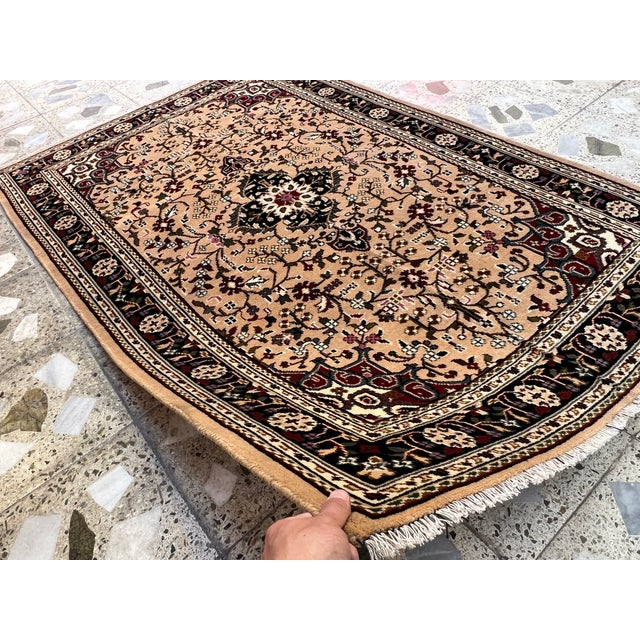 This exquisite hand-knotted wool area rug features a classic Caucasian design. The center field displays a prominent, dark...