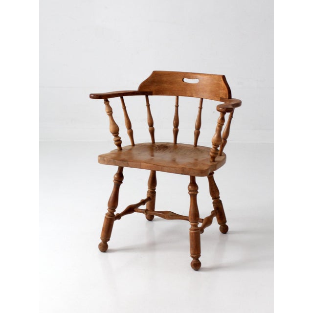 A classic vintage Ethan Allen Windsor armchair, grounded in the timeless appeal of Colonial Revival and Early American...