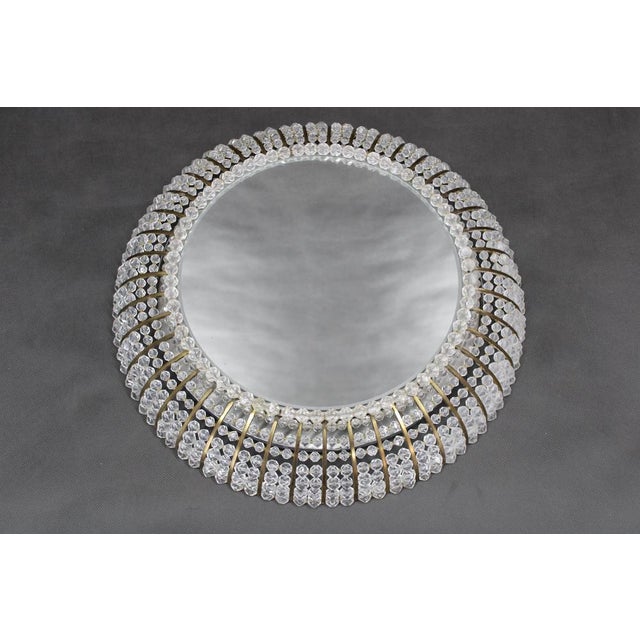 A refined Hollywood Regency illuminated wall mirror produced in Austria during the 1970s, combining decorative elegance...