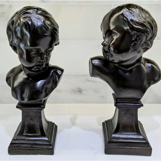 A handsome and dramatic pair of vintage Alva Studios authentic reproduction child busts, produced as museum-inspired...