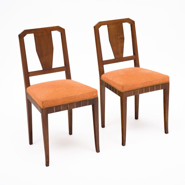 Pair of dining chairs from France made of solid wood construction, primarily walnut. The pair have a beautiful cut out...