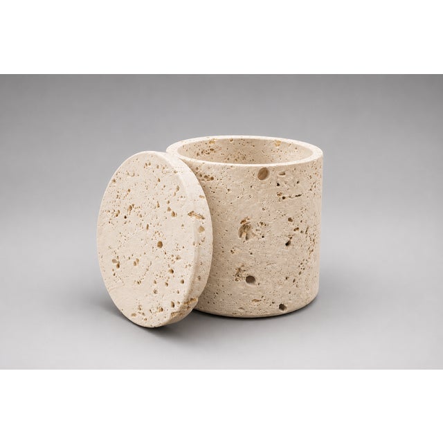 A beautifully handcrafted travertine stone jar with matching lid, showcasing the timeless appeal of natural materials and...