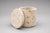 A beautifully handcrafted travertine stone jar with matching lid, showcasing the timeless appeal of natural materials and...