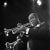 This black-and-white photo captures jazz legend Louis Armstrong playing his trumpet during a performance in Berlin in...