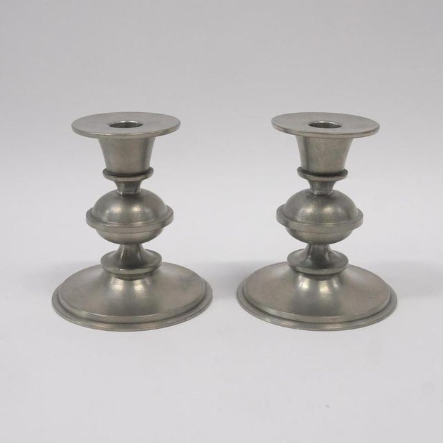 A pair of Scandinavian modern pewter candlesticks designed by Edvin Ollers and produced by Schreuder & Olsson, Sweden....