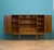 A 1960s Continental walnut highboard cabinet with beautifully figured book-matched veneers, elegant tapered legs and a...