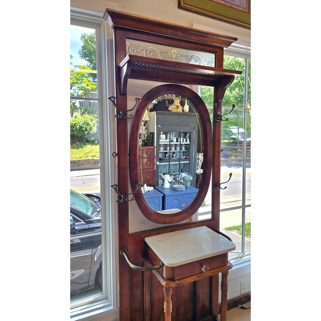 Vintagew apothecary Hallstand. It has an oval mirror that swivels. A handpainted gold border just inside the mirror's...