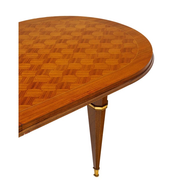Dining table from mid-century France made of a solid wood construction. The top features a striking Rosewood parquetry...