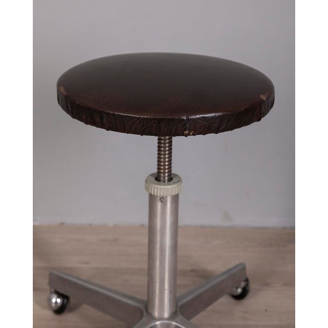 Stool with wheels, chromed metal frame and adjustable brown leather seat, made in Italy in the 1960s, industrial design.