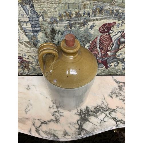 Charming antique wine jug stamped “James Pearson Chesterfield”, crafted in beige glazed stoneware. This ceramic demijohn...