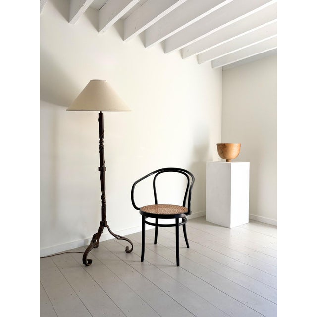 A French forged metal floor lamp with a tripod base and decorative scrolled feet. The barley twist details to the stem are...