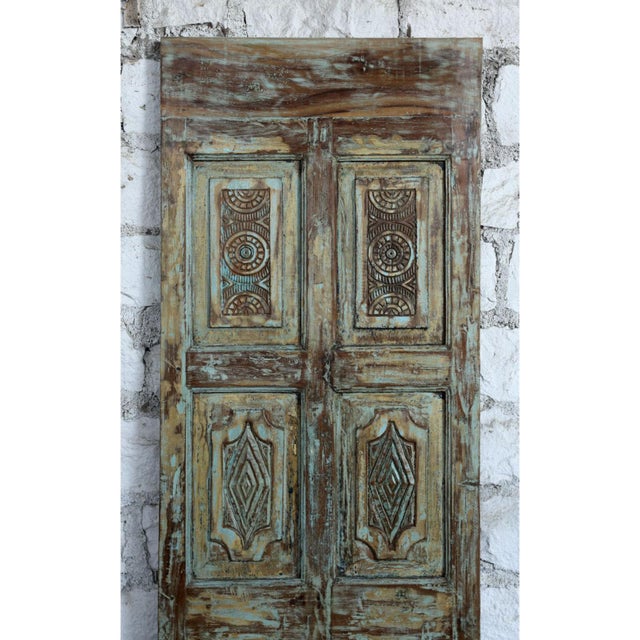 A striking piece of architectural salvage, this vintage single sliding barn door showcases intricately hand-carved...