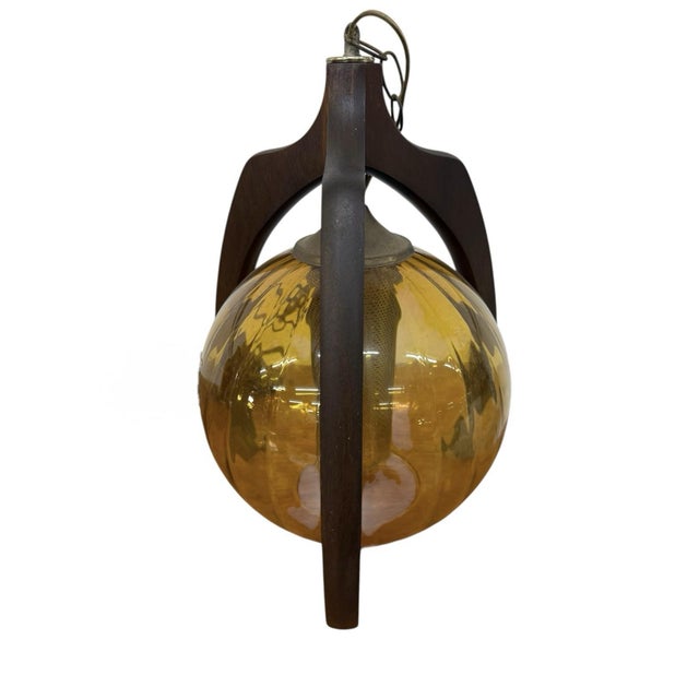 The Mid-Century Modern 1960’s Pearsall Style Walnut & Amber Glass Swag Light is a vintage piece perfect for any occasion....