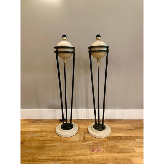 A Pair of floor lamps from the post modern era by American designer Michael Taylor, with travertine bases supporting a...