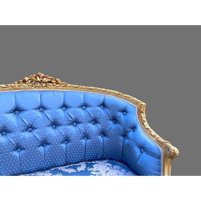A refined 1950s French Louis XVI–style settee, handcrafted in solid beechwood and newly restored with an antique gold...