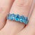 Elegant and vibrant, this stunning multi-stone ring showcases a row of brilliant Blue Topaz gemstones, offering a...