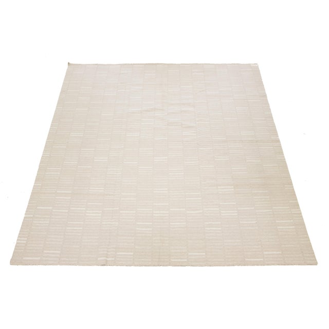 This rug showcases an organic modern design with a wool Kilim flatweave and features a geometric pattern in beige and...
