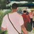 Three figures walk away from the viewer down a sandy path in this acrylic on canvas, bags slung over their shoulders and...