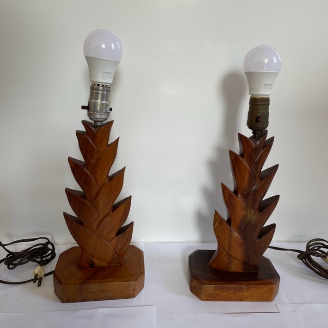 A pair of vintage 1930’s Hawaiian table lamps. The lamps are in a hand carved wood depicting pineapple leaves. The lamps...