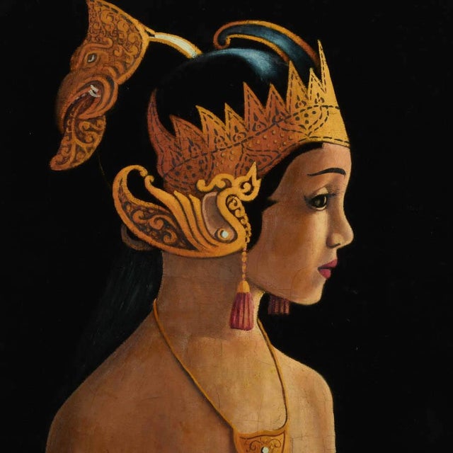 This Framed Signed Painting on Velvet of a Bali Woman features a Balinese woman in traditional attire, such as a sarong,...