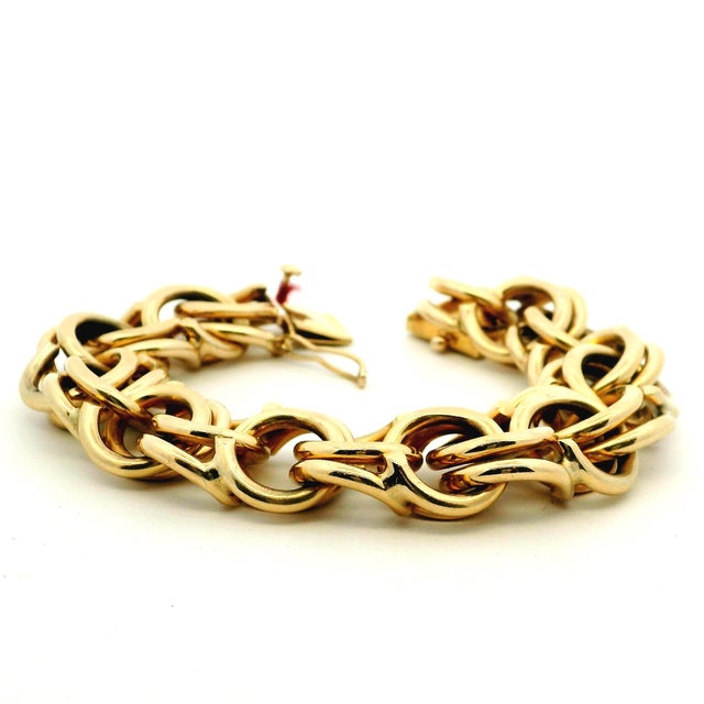 A substantial vintage Italian bracelet crafted in solid 14K yellow gold, featuring bold interlocking links with a smooth,...