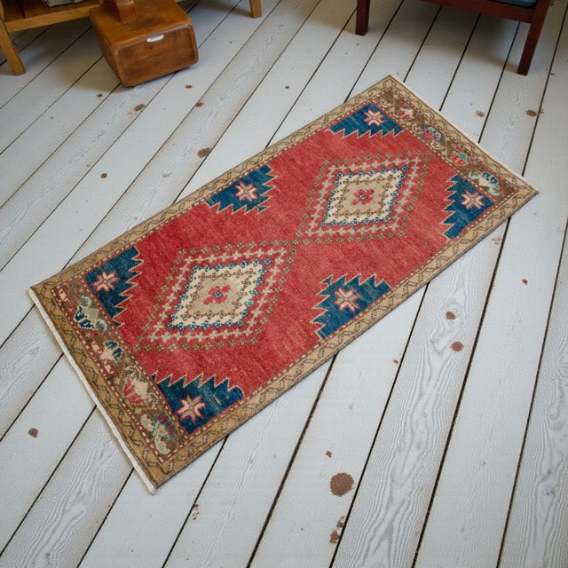 This vintage Oushak mat features a vibrant terracotta field adorned with two striking geometric medallions. Its sun-faded...