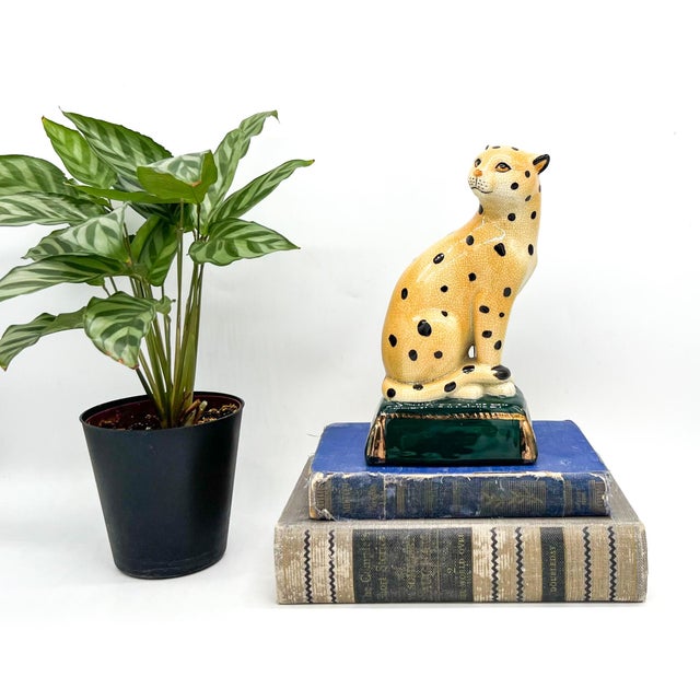 Adorable vintage ceramic cheetah with a warm crackle glaze, hand-painted black spots, expressive amber eyes, and a deep...