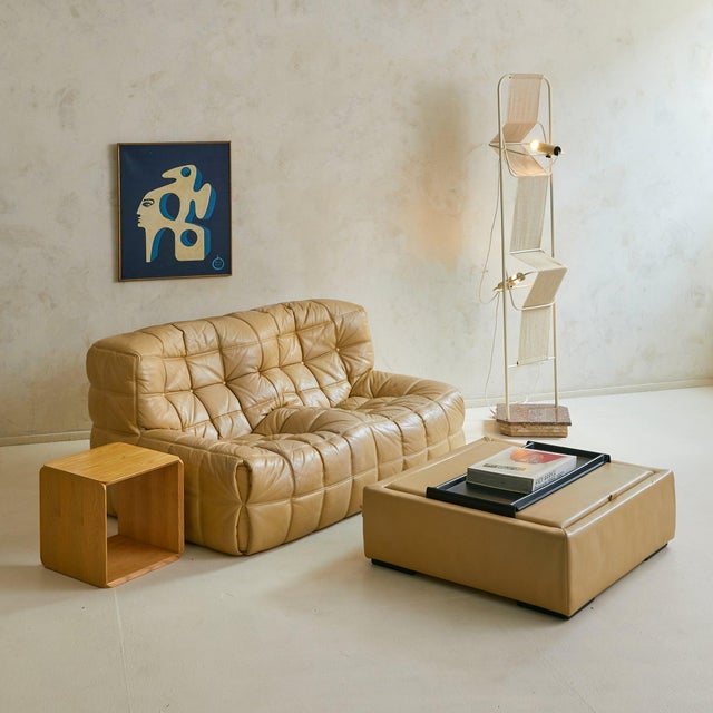 A rare 1970s coffee table by Ligne Roset, France. Wrapped in supple ecru-toned leather, the low square form is softly...