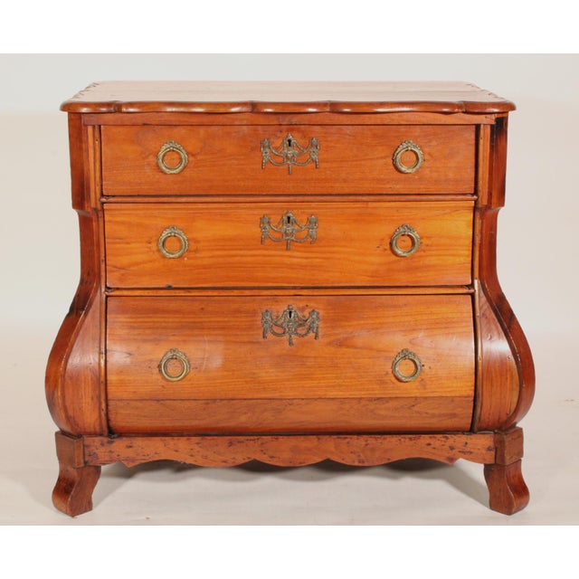 Dutch fruit wood kettle base chest of drawers, 19th century. The top with scalloped front and side edges, 3 graduated...