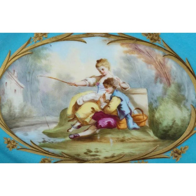 Oval blue porcelain cup with polychromatic decoration composed of a large cartouche with gilt-decorated borders depicting...