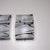 Pair of wall sconces featuring wavy glass shades crafted from white smoked glass with subtle black inclusions. The shades...