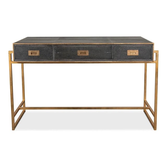 A modern shagreen embossed leather-wrapped desk with a brass tone iron-framed base. Three drawers with marbleized paper-...