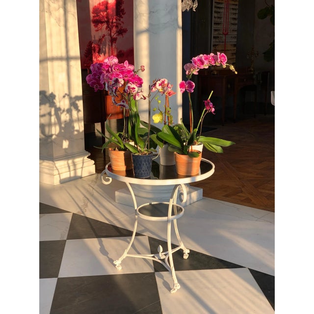 This neoclassical Directoire style Gueridon/side -table has an "absolute" black granite top and lower shelf. The brass is...