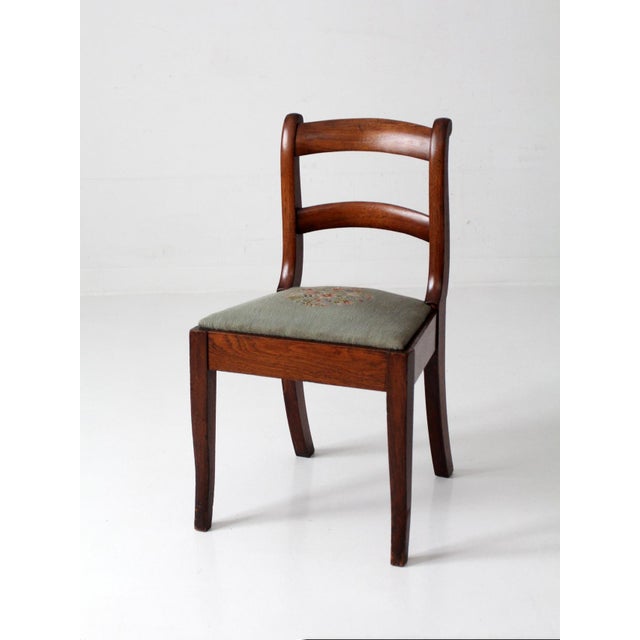 Early 20th century French country ladder-back chair with a needlepoint seat in a muted floral motif on a soft ground....