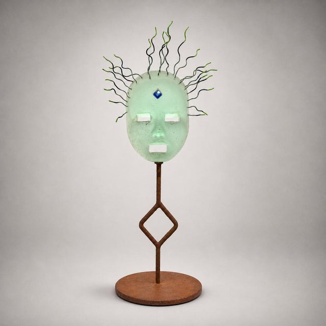 A sculpture by pino signoretto, characterized by a strong sculptural component and refined glasswork. the blown glass face...