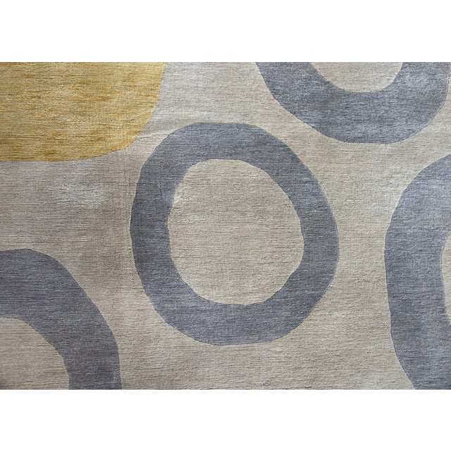 A striking vintage Tibetan hand-knotted wool rug with two dark red circles and several gray and yellow circles against a...
