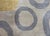 A striking vintage Tibetan hand-knotted wool rug with two dark red circles and several gray and yellow circles against a...