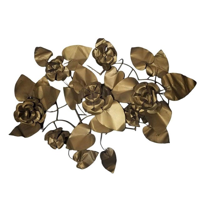 Mid-century Tole hand-folded metal floral wall sculpture. The wall-hanging sculpture delicately formed flowers and leaves...