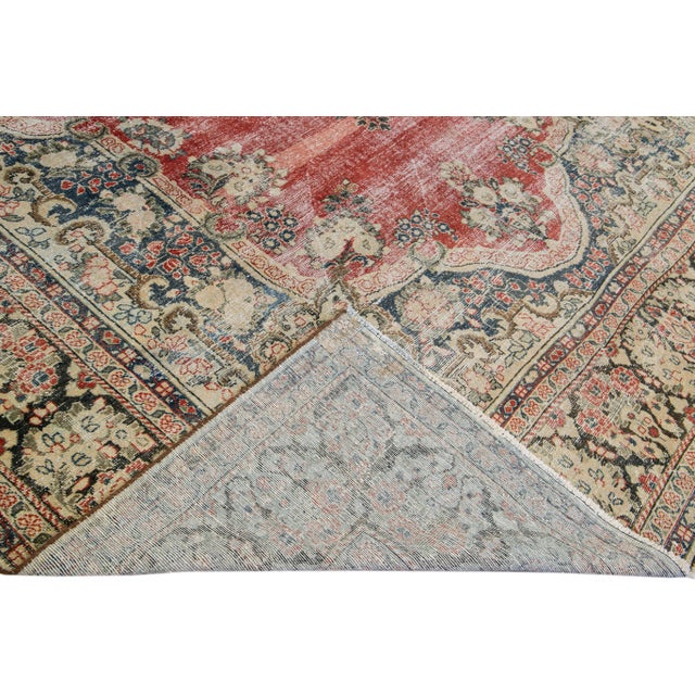 Beautiful Vintage Persian distressed hand-knotted wool rug with a red color field. This Persian rug has a beige frame and...
