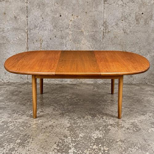 A beautifully proportioned mid-century teak extending dining table by Elliots of Newbury, with a softly rounded oval form,...