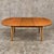 A beautifully proportioned mid-century teak extending dining table by Elliots of Newbury, with a softly rounded oval form,...
