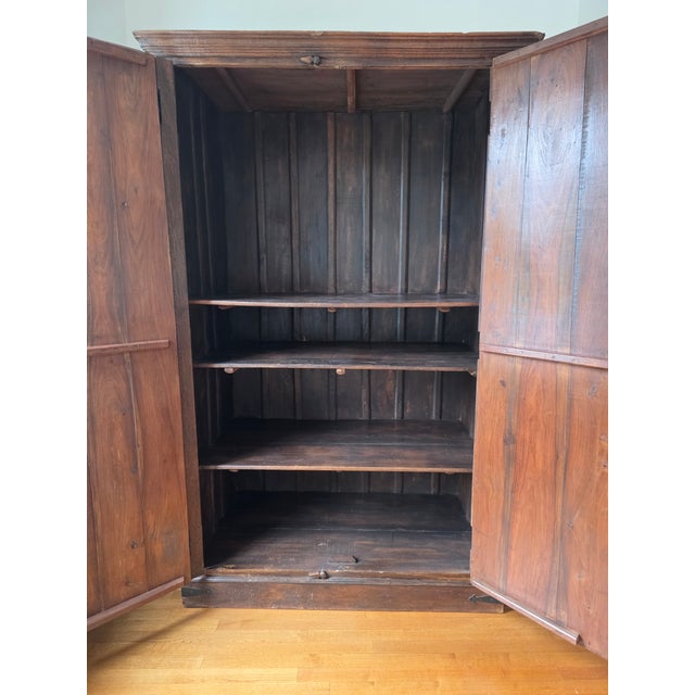 Large mid 20th century European style rustic two-door armoire adorned with an ornate haveli style brass overlay. Solid...
