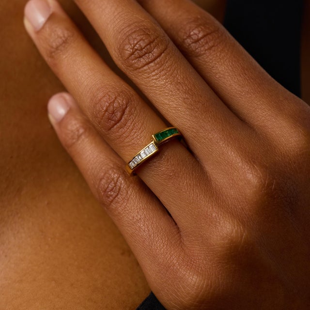 This elegant vintage band showcases a refined alternating design of 6 baguette cut diamonds and 6 step cut emeralds, each...