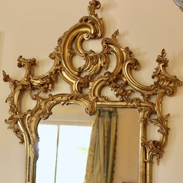 A finely carved Italian giltwood mirror in the George III style with exuberant asymmetrical Rococo motifs well executed...