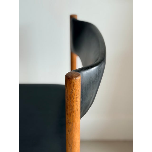 The chair features a beautifully proportioned wooden frame with slender rounded legs and a characteristic curved...