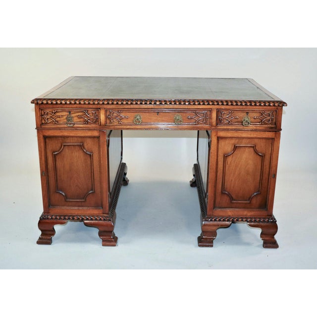 This exquisite partner's desk is a fine example of Chippendale-style furniture, characterized by its intricate and ornate...