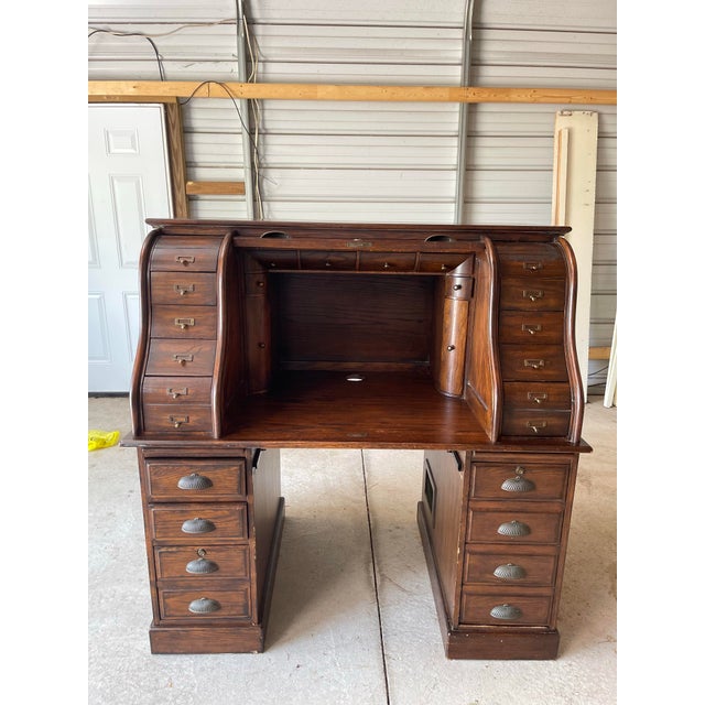 Beautiful vintage roll-top desk featuring a classic curved tambour front, paneled sides, and a rich dark oak brown wood...